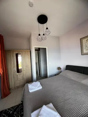a bedroom with a bed and a chandelier at Eleni's Seaview House in Saronida