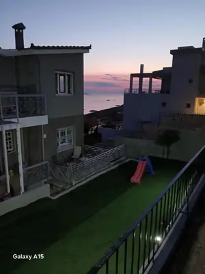 a backyard with a slide on the roof of a house at Eleni's Seaview House in Saronida