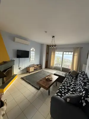 a living room with a couch and a table at Eleni's Seaview House in Saronida