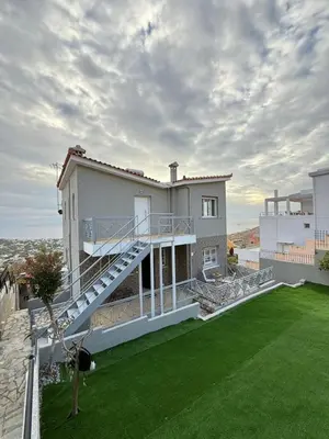 a large house with a balcony and a lawn at Eleni's Seaview House in Saronida