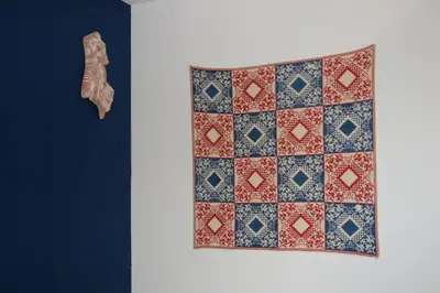 a quilt and a shoe on a wall at Aegean Grace in Áyios Dhimítrios