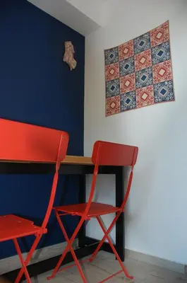 a red chair and a desk in a room at Aegean Grace in Áyios Dhimítrios