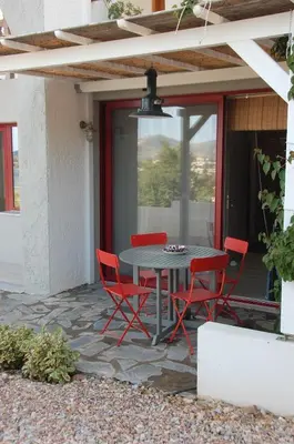 a patio with a table and chairs on a patio at Aegean Grace in Áyios Dhimítrios