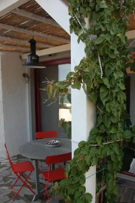 a table and chairs on a patio with a plant at Aegean Grace in Áyios Dhimítrios
