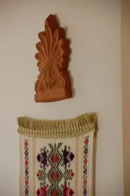a decorative towel hanging on a wall with a wooden nicotinterness at Aegean Grace in Áyios Dhimítrios