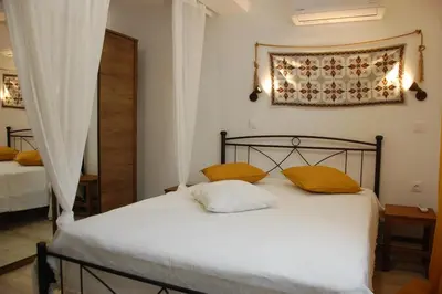 a bedroom with a bed with two yellow pillows at Aegean Grace in Áyios Dhimítrios