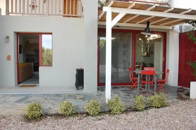 a patio with a table and chairs on a house at Aegean Grace in Áyios Dhimítrios