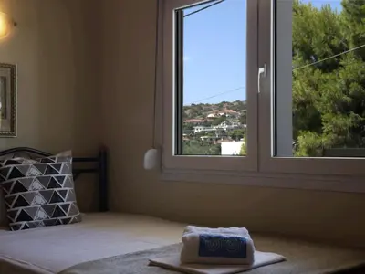 a bedroom with a window with a towel on a bed at Chara's Luxury Home in Vravrona