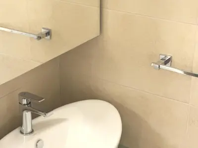 a bathroom with a white toilet and a sink at Chara's Luxury Home in Vravrona