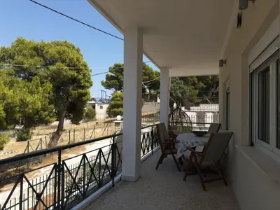 a balcony with a table and chairs and a view of a field at Chara's Luxury Home in Vravrona