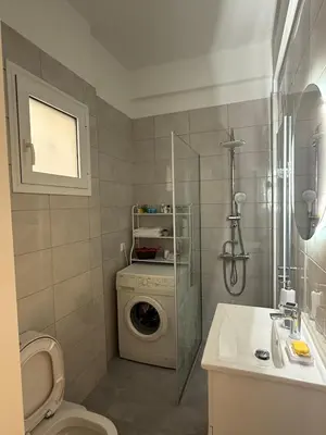 a bathroom with a washing machine and a washer at A nest for two in Athens in Mesochórion