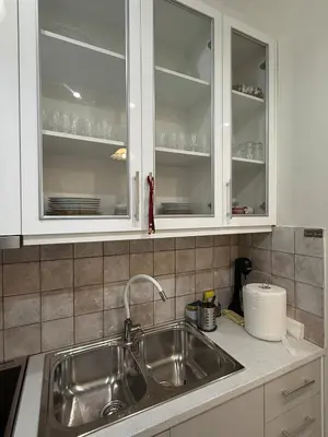 a kitchen with white cabinets and a sink at A nest for two in Athens in Mesochórion