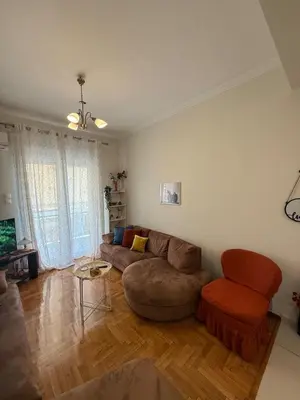 a living room with a couch and a chair at A nest for two in Athens in Mesochórion