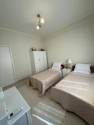 a bedroom with two beds and a desk at A nest for two in Athens in Mesochórion