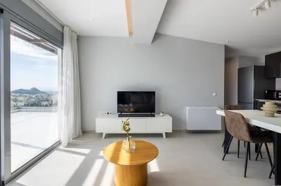 a living room with a television and a table with chairs at Athens Sky Loft in Athens