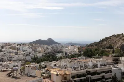 a city with buildings and a mountain in the background at Athens Sky Loft in Athens