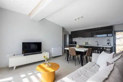 a living room with a couch and a tv and a kitchen at Athens Sky Loft in Athens