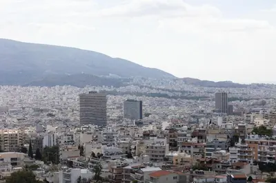 a city with buildings and mountains in the background at City Lights Residence Psyxiko in Athens