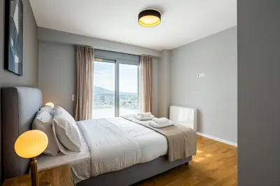 a bedroom with a bed and a large window at City Lights Residence Psyxiko in Athens