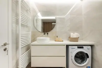 a bathroom with a washing machine and a mirror at City Lights Residence Psyxiko in Athens
