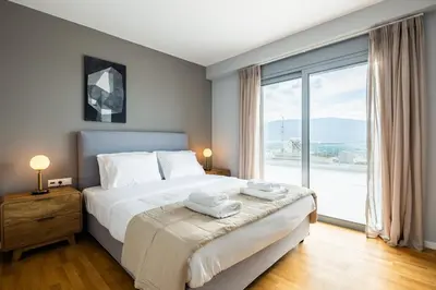 a bedroom with a large bed and a large window at City Lights Residence Psyxiko in Athens