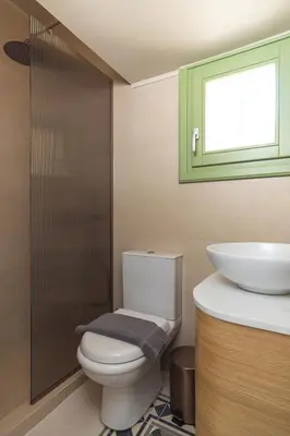 a bathroom with a toilet and a sink and a window at Ogigou Suites in Athens