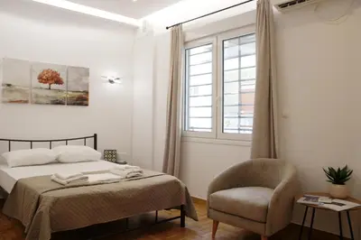 a bedroom with a bed and a chair and a window at ARIS Urban Exarchia in Athens