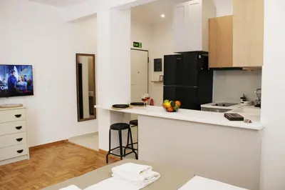 a kitchen with white counters and a black refrigerator at ARIS Urban Exarchia in Athens