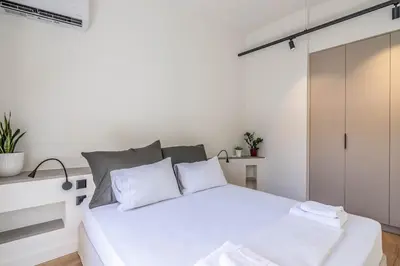 a bedroom with a white bed with white pillows at Athenian Sky, Two Bedroom Apartment in Koukaki in Athens