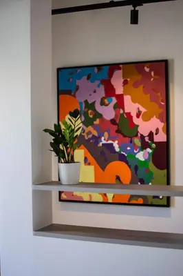 a painting on a wall with a plant on a shelf at Athenian Sky, Two Bedroom Apartment in Koukaki in Athens