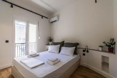 a white bedroom with a bed with towels on it at Athenian Sky, Two Bedroom Apartment in Koukaki in Athens