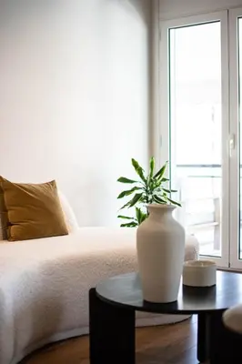 a bedroom with a bed with a vase on a table at Athenian Sky, Two Bedroom Apartment in Koukaki in Athens