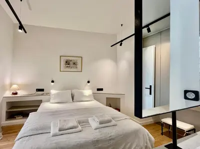 a bedroom with a large white bed and a mirror at Chic Central Gem Walk to Acropolis in 10 minutes in Athens
