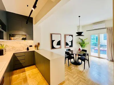 a kitchen and dining room with a table and chairs at Chic Central Gem Walk to Acropolis in 10 minutes in Athens