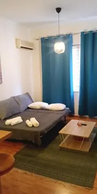 a bedroom with a bed and a blue curtain at Argy's cozy apartment in Pireaus Port in Piraeus