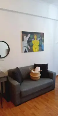 a living room with a gray couch and a table at Argy's cozy apartment in Pireaus Port in Piraeus