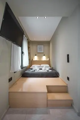 a bedroom with a large bed and a flat screen tv at Kais 1st floor studio in Athens