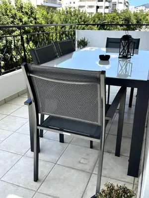 a table and chair sitting on top of a balcony at Her Luxury Apartment in Athens