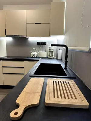 a kitchen with a sink and a wooden cutting board at Her Luxury Apartment in Athens
