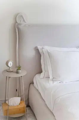 a bedroom with a white bed with a side table at The HostMaster WiseView Azure in Athens
