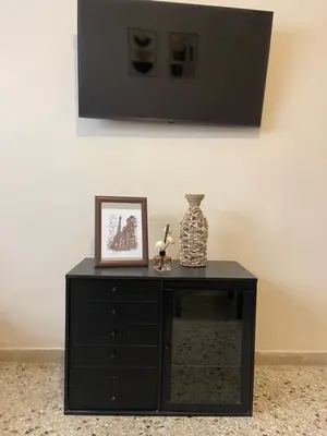 a black cabinet with a picture and a vase on it at The Athenian Filo by Mountain Hotels in Athens