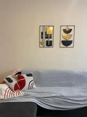 a living room with a couch and two pictures on the wall at The Athenian Filo by Mountain Hotels in Athens