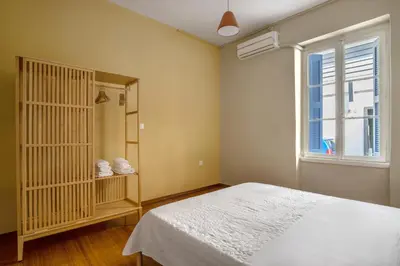 a bedroom with a bed and a window at Grand Haven - New Renovated Spacious Apts in Prime Location in Athens