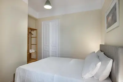 a bedroom with a white bed with white pillows at Grand Haven - New Renovated Spacious Apts in Prime Location in Athens