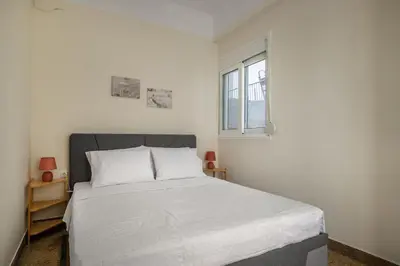 a bedroom with a bed and a window at Grand Haven - New Renovated Spacious Apts in Prime Location in Athens