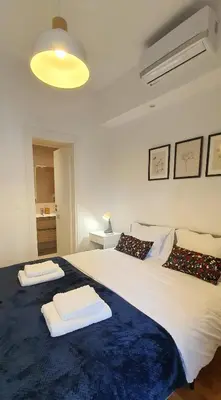 a bedroom with a large bed with towels on it at Condo, Hilton & Caravel area, Athens Center in Athens