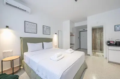a bedroom with a large white bed with towels on it at Zen Rhea - Urban Spacious Loft in Athens Center in Athens