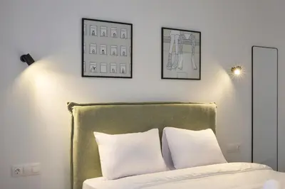 a bedroom with a green headboard and two white pillows at Zen Rhea - Urban Spacious Loft in Athens Center in Athens