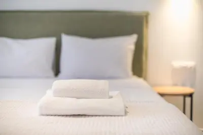 two towels sitting on top of a bed at Zen Rhea - Urban Spacious Loft in Athens Center in Athens