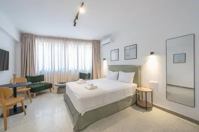 a hotel room with a bed and a table and chairs at Zen Rhea - Urban Spacious Loft in Athens Center in Athens
